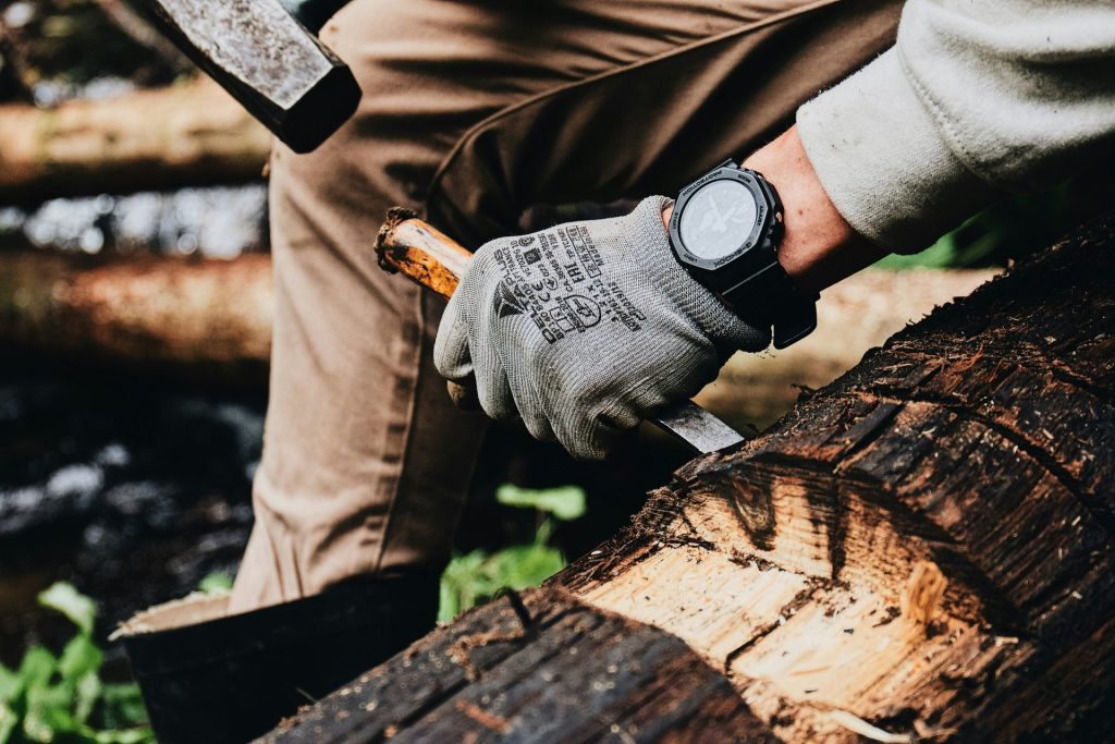 a man is holding a large knife and a log